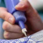 Rhian Malin decorating a mandala bottle in her workshop 2019